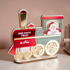 Décor en bois et relief coloré représentant une locomotive. Il est inscrit « Mon petit train de Noël ». Le père-noël sort la tête par la fenêtre. Le décor est rouge, vert olive et doré. 
