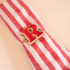 Lettre « R » en bois et relief plexi miroir rouge accroché sur une serviette à rayures blanche et rouge 