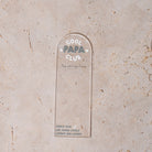 Marque-pages en plexi transparent découpe forme arche, texte blanc et vert. Inscription dans l’arche sur 3 lignes « Cool Papa Club », 2 smiley entourent le mot « PAPA ». Les mots « cool » et « club » et les motifs sont inscrits en blanc, le reste du texte est en couleur.
En dessous est inscrit un prénoms (personnalisation du produit) 
En bas du marque-page est inscrit « Parque les papas cools lisent des livres » disposé sur 3 lignes avec un dessin de main en « v » 