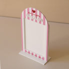 Cadre en plexiglass blanc
Modèle rayé rose et texte rouge
Découpe forme arche sur socle blanc
Impression : rayures verticales, partie demi-cercle personnalisé avec inscription sur 3 ligne d’un coeur de « bonne fête » et de  « maman ».
Mot « maman » en relief plexi blanc
Inscription sur le bas du cadre de la phrase « reine de mon coeur » (phrase personnalisable)
Ouverture cadre rectangulaire
