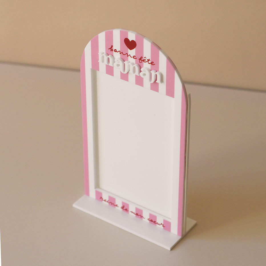 Cadre en plexiglass blanc
Modèle rayé rose et texte rouge
Découpe forme arche sur socle blanc
Impression : rayures verticales, partie demi-cercle personnalisé avec inscription sur 3 ligne d’un coeur de « bonne fête » et de  « maman ».
Mot « maman » en relief plexi blanc
Inscription sur le bas du cadre de la phrase « reine de mon coeur » (phrase personnalisable)
Ouverture cadre rectangulaire