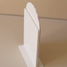 Verso cadre en plexiglass blanc
3 épaisseurs sur socle 
Face avant découpe en forme d’arche
Face arrière découpe forme rectangulaire