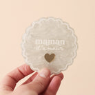 Miroir de poche forme rond festonné avec impression contour, inscription « maman d’amour » et coeur en plexi miroir incrusté au centre. Coloris face marbré blanc : fond plexi marbré blanc, contour et teste blanc, coeur en plexi miroir or 