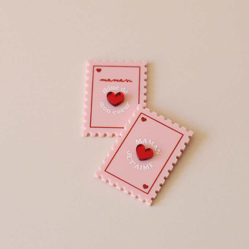 Magnet en plexi coloré rose et rouge, design de carte à jour, forme de timbre et coeur au centre en relief.  Inscription maman je t’aime ou reine de mon coeur 