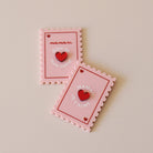 Magnet en plexi coloré rose et rouge, design de carte à jour, forme de timbre et coeur au centre en relief.  Inscription maman je t’aime ou reine de mon coeur 