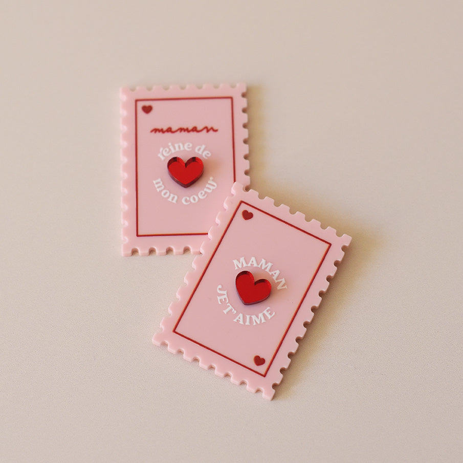 Magnet en plexi coloré rose et rouge, design de carte à jour, forme de timbre et coeur au centre en relief.  Inscription maman je t’aime ou reine de mon coeur 